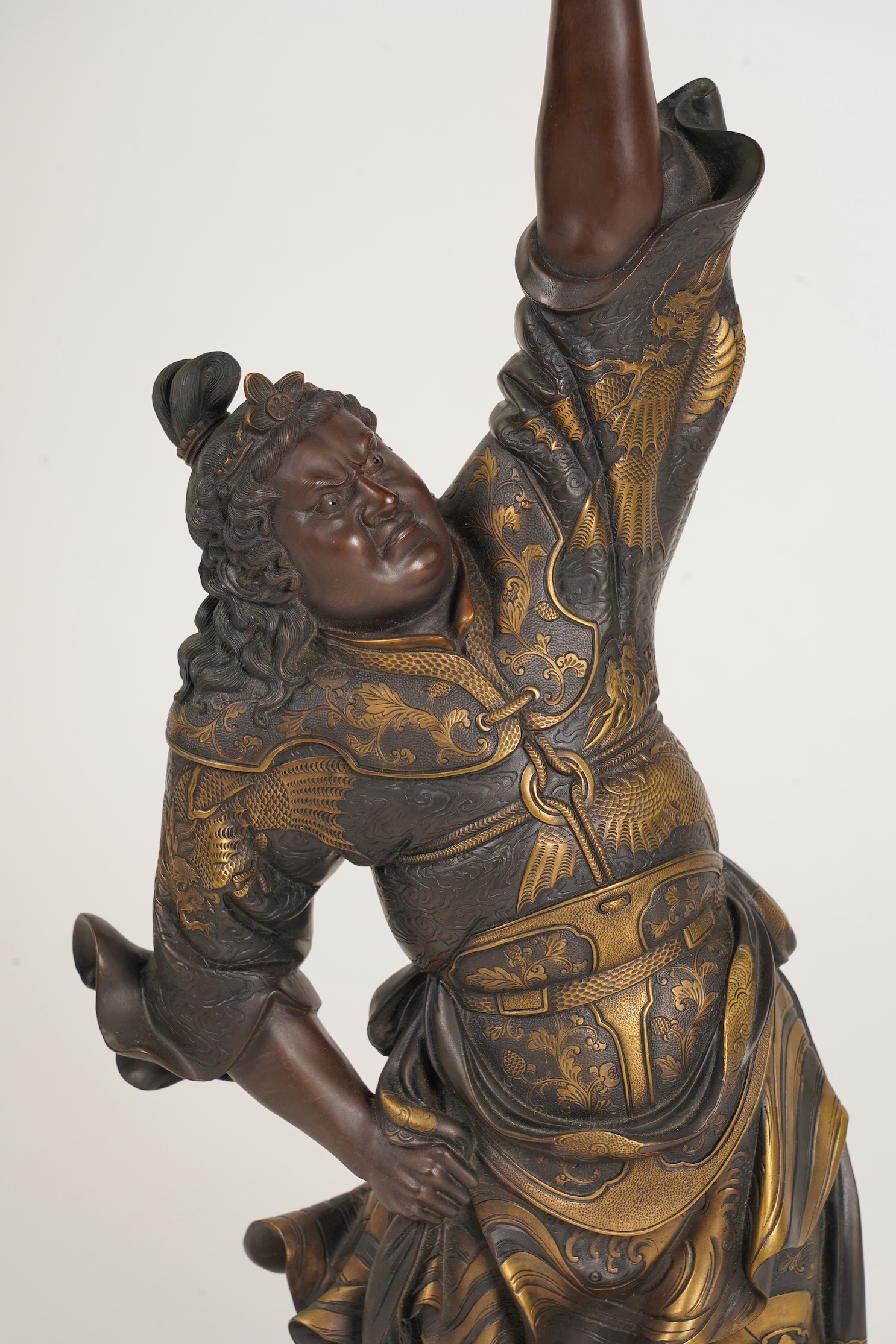 A large Japanese Miyao style parcel gilt bronze figure holding a koro aloft, 20th century